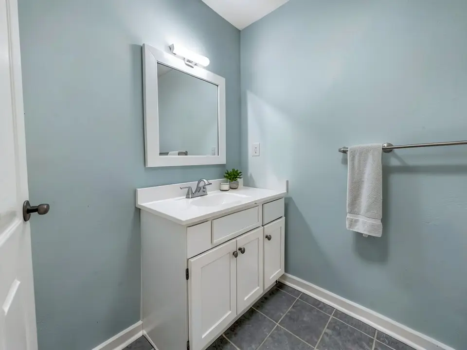 The same bathroom with the walls painted a pale blue-gray