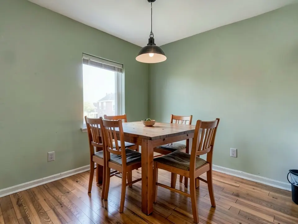 The same dining room with the walls painted a muted sage green