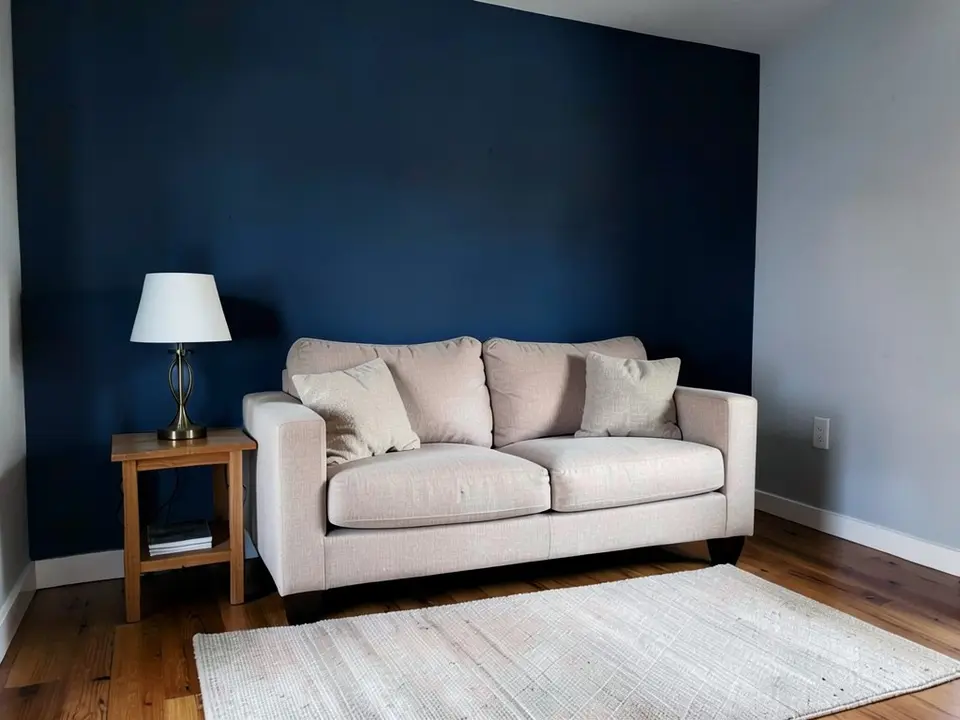 The same living room with the wall behind the sofa painted deep navy blue