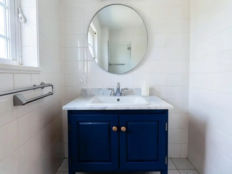 The same bathroom with the vanity cabinet painted deep navy blue