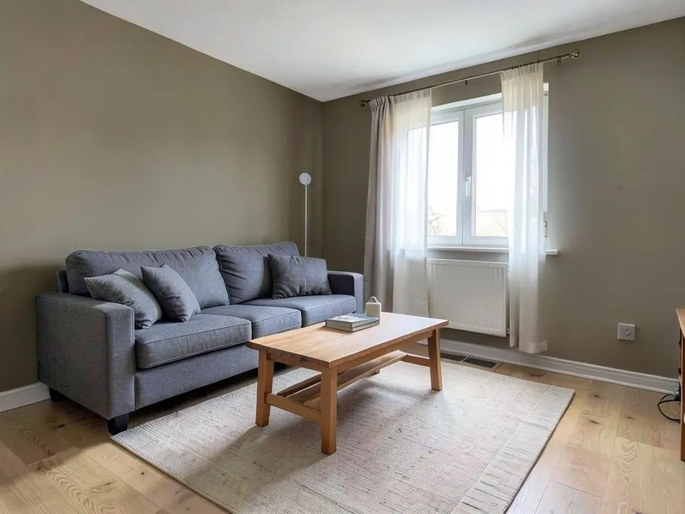 The same living room with the walls painted a medium-dark warm taupe, with the sofa, coffee table, rug, floor and curtains kept