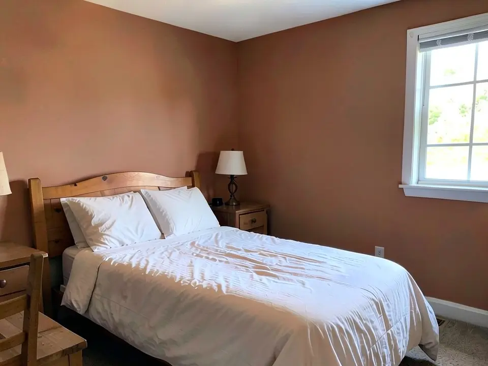 The same bedroom with the walls painted a dusty terracotta orange-brown